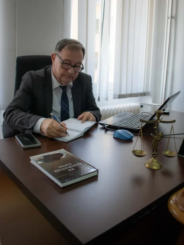 Advokat Mileta B. Radojević pruža pravne usluge u Beogradu, prikazan dok piše beleške u knjigu